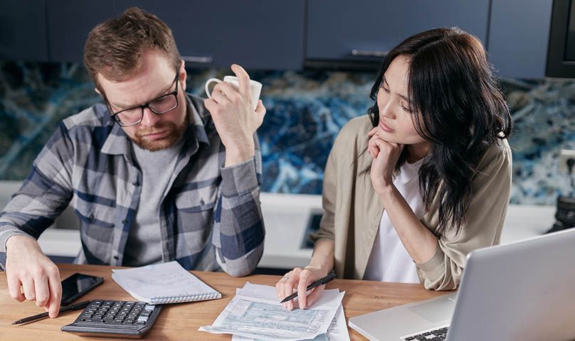 worried couple working out finances with a calulator